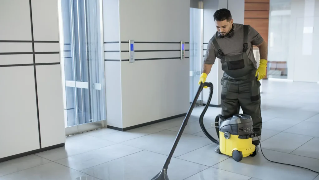 full-shot-man-vacuuming-office-floor Pourquoi Choisir une Entreprise de Nettoyage